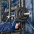 Male athlete performing chest press with Olympic weight plates