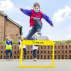 Boy jumping over yellow hurdle