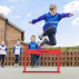 Boy jumping over red hurdle